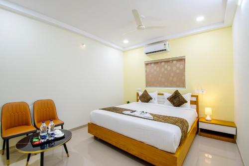 a bedroom with a bed and a table and chairs at 4 Colors Hotels Kondapur in Lingampalli