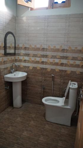 a bathroom with a toilet and a sink at Vijay Residency in Barkot