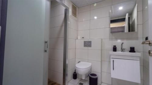 a white bathroom with a toilet and a shower at Elegance Sirius in Kayseri