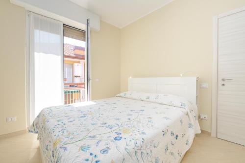 a white bedroom with a bed and a window at 320 - Casa Scorcio di Mare A due passi dal centro e dal mare di Riva Trigoso in Riva Trigoso