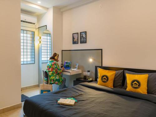 a woman standing at a desk in a room with a bed at The Hosteller Bangalore, Koramangala in Bangalore