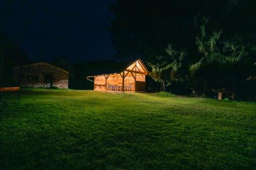 a barn in a field at night with a green yard at Villa with a covered pool, park, and playground in Svoboda nad Úpou