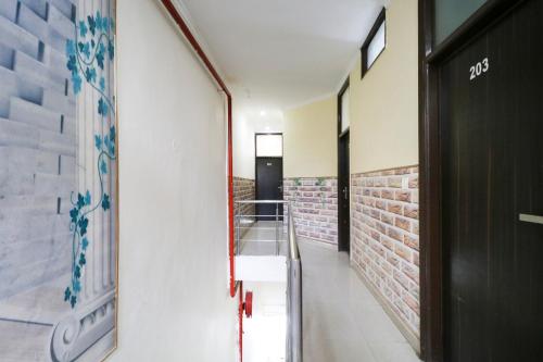 a hallway with a door and a brick wall at Hotel O Kuber 7 in Zirakpur