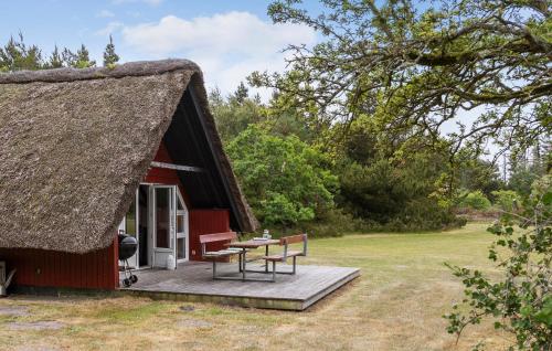 a red cottage with a thatched roof with a deck at Beautiful Home In Rømø With House A Panoramic View in Toftum