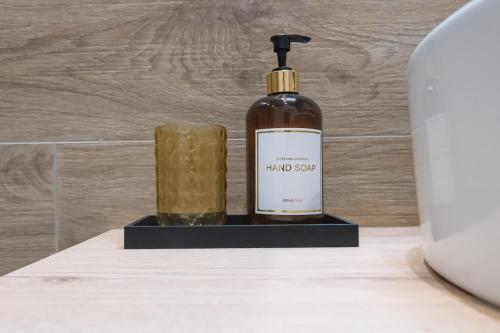 a bottle of soap and a candle on a counter at Luxury central apartment 6,3 in Larisa