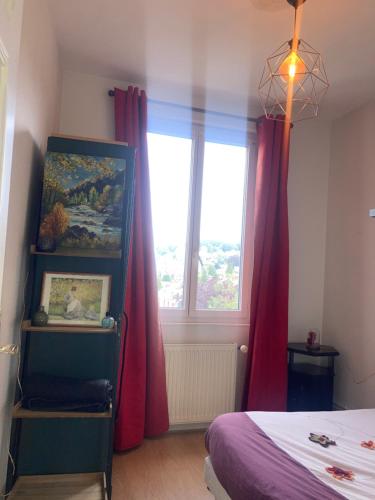 une chambre avec un lit et une fenêtre avec des rideaux rouges dans l'établissement Terra's Room, à Rouen