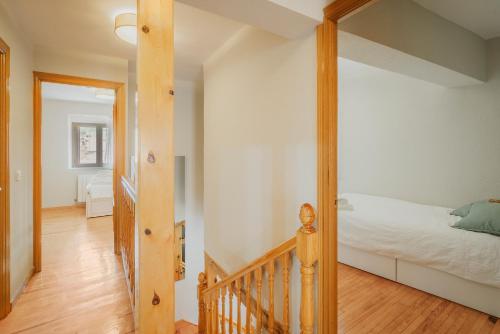 a bedroom with a bed and a wooden staircase at La Cabaña de Cascajares in Cascajares de la Sierra