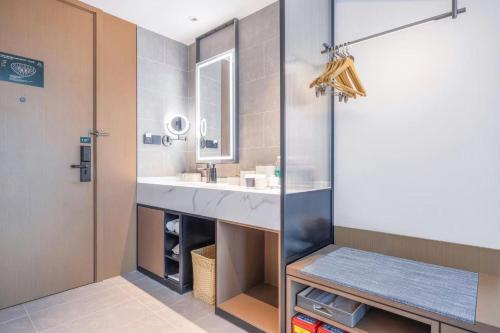 a bathroom with a sink and a mirror at Atour Hotel Jinan Jingshidong Road Medicine Valley in Jinan