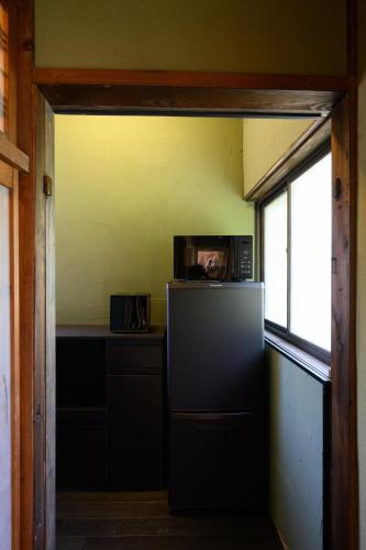 a kitchen with a refrigerator and a microwave at Kino in Takamatsu