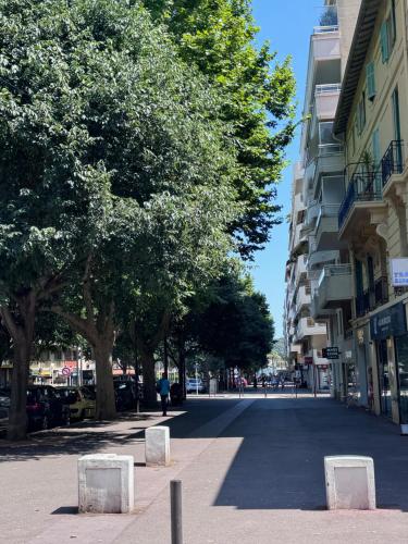 a street in a city with trees and buildings at Le Nid Douillet du Carré d'OR in Antibes