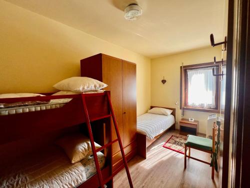 a small room with a bunk bed and a bedroom at Solarium e area Giochi - Vicino ad Asiago - Garage in Roana