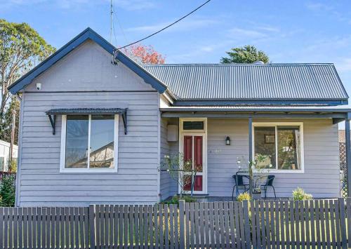 a blue house with a fence in front of it at Cottage on Lords in Orange