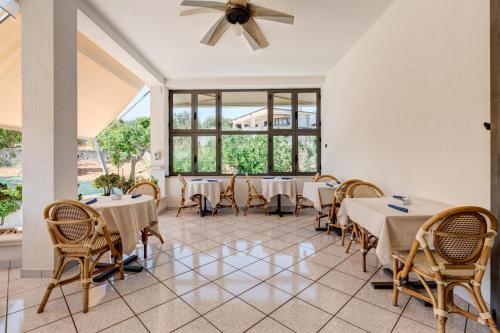 a dining room with tables and chairs and windows at Piccolo Hotel Villa Rosa in Ostuni