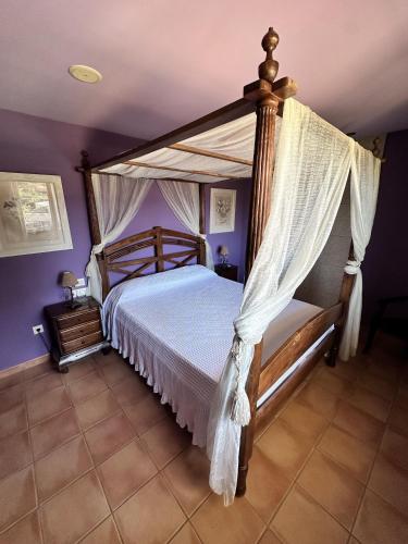 a bedroom with a canopy bed and a tiled floor at As Adegas in Poio