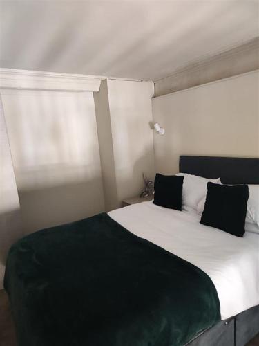 a bedroom with a large bed with black and white pillows at Central City Apartment in Central Station