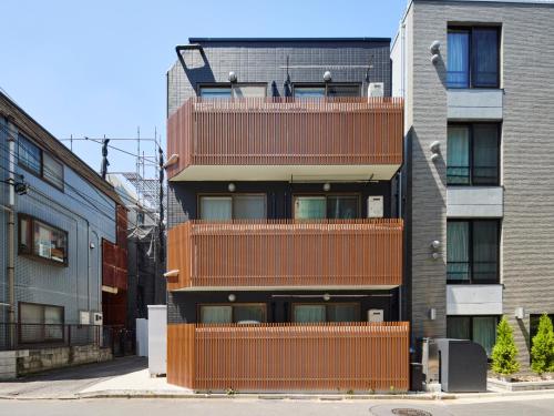 an apartment building with balconies on a city street at tokyo Japandi apartment ikebukuro in Tokyo