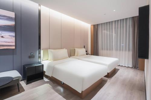 a hotel room with a bed and a tv at Atour Hotel Jinan Jing Si Road Wanda Plaza in Jinan