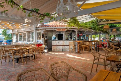 a restaurant with tables and chairs and a bar at Alex bar apartments in Sarakiniko