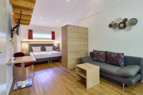 a living room with a couch and a bed at Moselhotel Weinhaus Simon `Sauna`Restaurant`ELadesäule in Wintrich