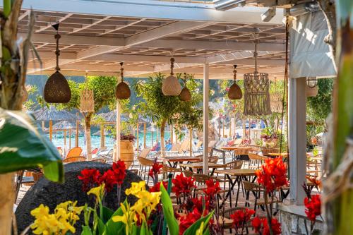 a restaurant with tables and flowers on a patio at Alex bar apartments in Sarakiniko