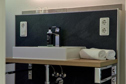 a bathroom with a sink and towels on a counter at Moselhotel Weinhaus Simon `Sauna`Restaurant`ELadesäule in Wintrich