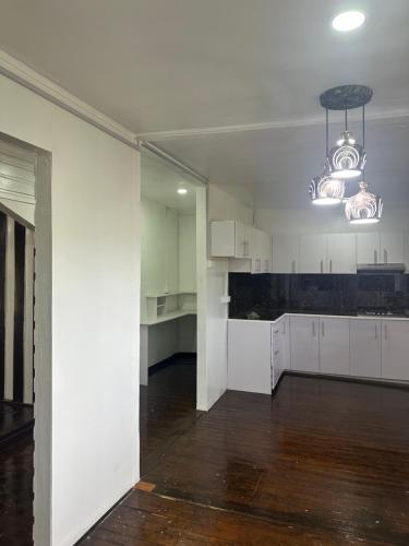 an empty kitchen with white cabinets and a chandelier at Large 3bdr Holiday Home Great Location Labasa Jumanzuls Abode in Labasa