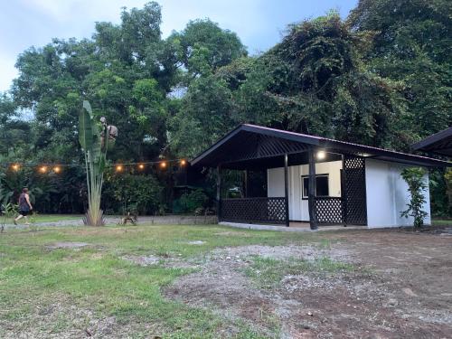 a black and white building with people walking in the yard at Playa Grande Lodge & Tree House in Cahuita