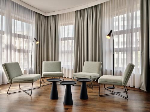 a waiting room with three chairs and two tables at Garner Hotel Berlin - Schöneberg by IHG in Berlin