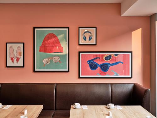a dining room with a table and pictures on the wall at Garner Hotel Berlin - Schöneberg by IHG in Berlin