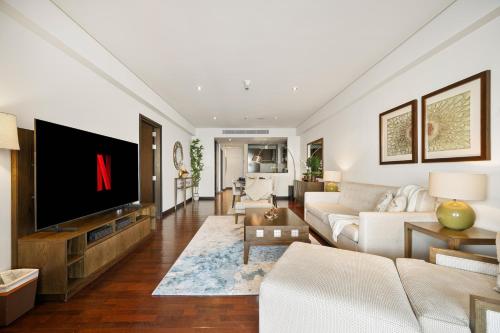 a living room with a tv and a couch at Luxury Apartments in Anantara Resort with Stunning Burj AlArab & Sea Views in Dubai