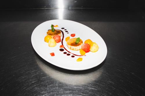 a white plate with fruit on a black table at Sunny Palms Beach Bungalows in Uroa