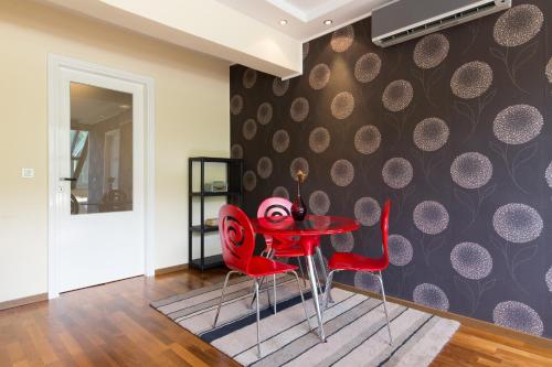 a dining room with red chairs and a table at Amazing Penthouse old town in Sarajevo