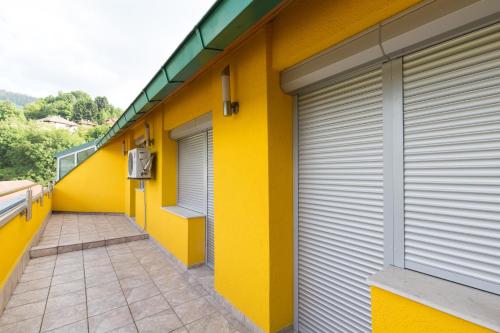 a yellow building with two garage doors and a walkway at Amazing Penthouse old town in Sarajevo