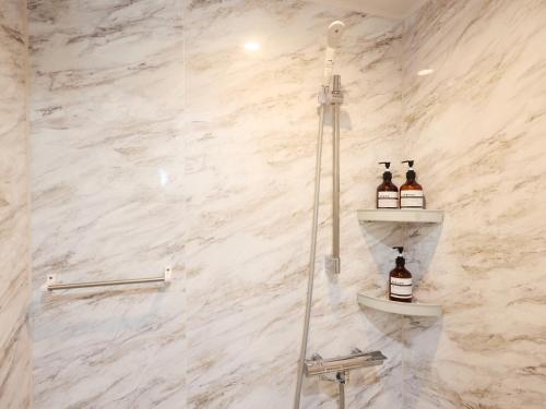 a bathroom with a shower with two bottles of beer at tokyo Japandi apartment ikebukuro in Tokyo