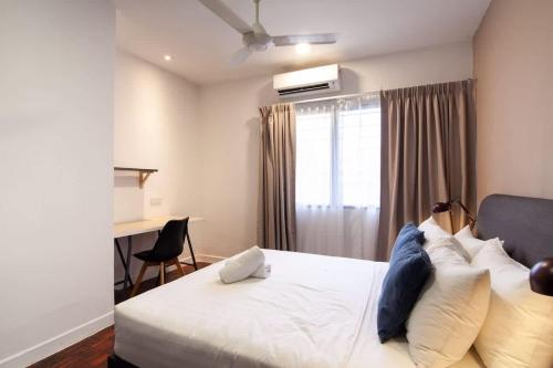 a bedroom with a white bed with a desk and a window at Bukit Damansara Terrace in Kuala Lumpur
