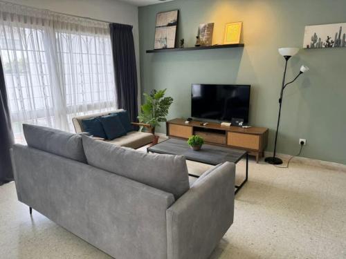a living room with a couch and a tv at Bukit Damansara Terrace in Kuala Lumpur