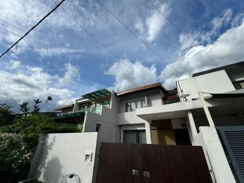 a large white house with a cloudy sky at Bukit Damansara Terrace in Kuala Lumpur