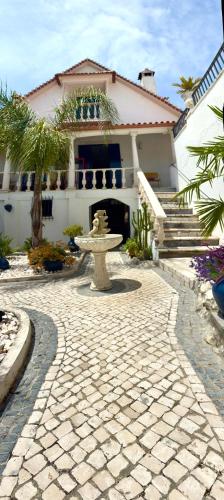 a stone walkway in front of a house with a fountain at Casal dos Frades in Fontainhas