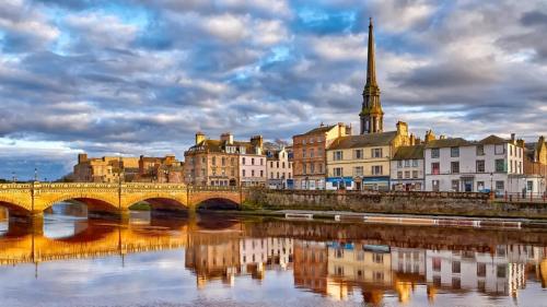 a city with a bridge and buildings and a river at Luxury Georgian Aparthotel by Hauss Ayr - 5mins to Beach, Town Centre! in Ayr