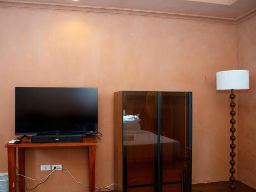 a living room with a flat screen tv and a lamp at Boracay Beach Club in Boracay