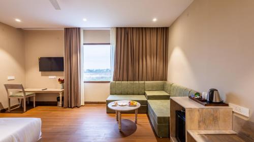 a hotel room with a couch and a table at Pallacia A Luxury Hotel in Beāwar