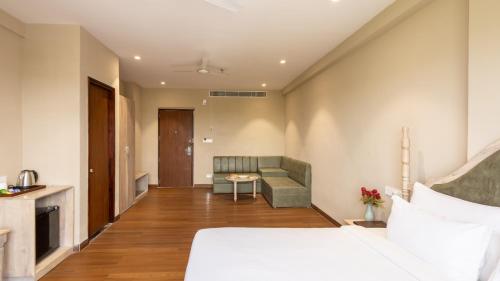a hotel room with a bed and a couch at Pallacia A Luxury Hotel in Beāwar