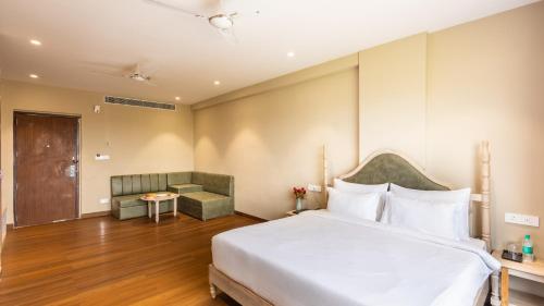 a bedroom with a large white bed and a couch at Pallacia A Luxury Hotel in Beāwar
