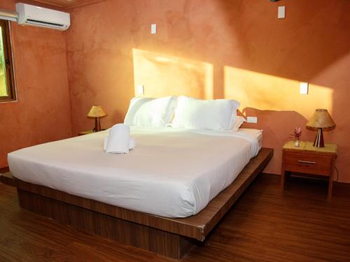 a bedroom with a large bed with white sheets and pillows at Boracay Beach Club in Boracay