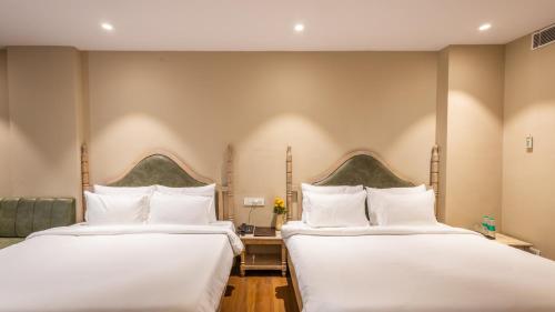 two beds in a hotel room with white pillows at Pallacia A Luxury Hotel in Beāwar