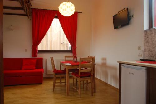 a living room with a table and a red couch at Bungalouri Horizont in Odorheiu Secuiesc