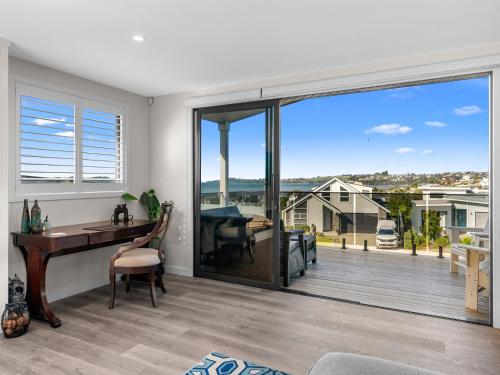 a home office with a desk and a large sliding glass door at Kawau Bay Escape - Snells Beach Holiday Home in Snells Beach