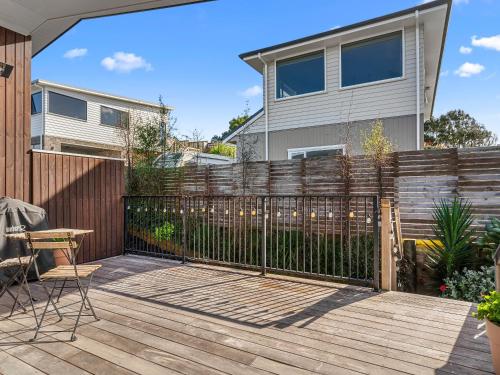 a wooden deck with a fence in front of a house at Kawau Bay Escape - Snells Beach Holiday Home in Snells Beach