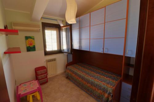 a bedroom with a bed and a chair and a window at Villa Belorizzonte - Relax & Sea in Mandra Capreria