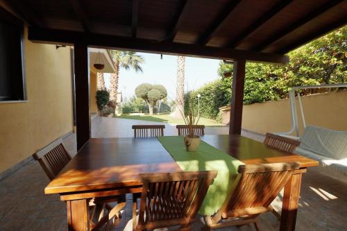 a wooden table and chairs on a patio at Villa Belorizzonte - Relax & Sea in Mandra Capreria